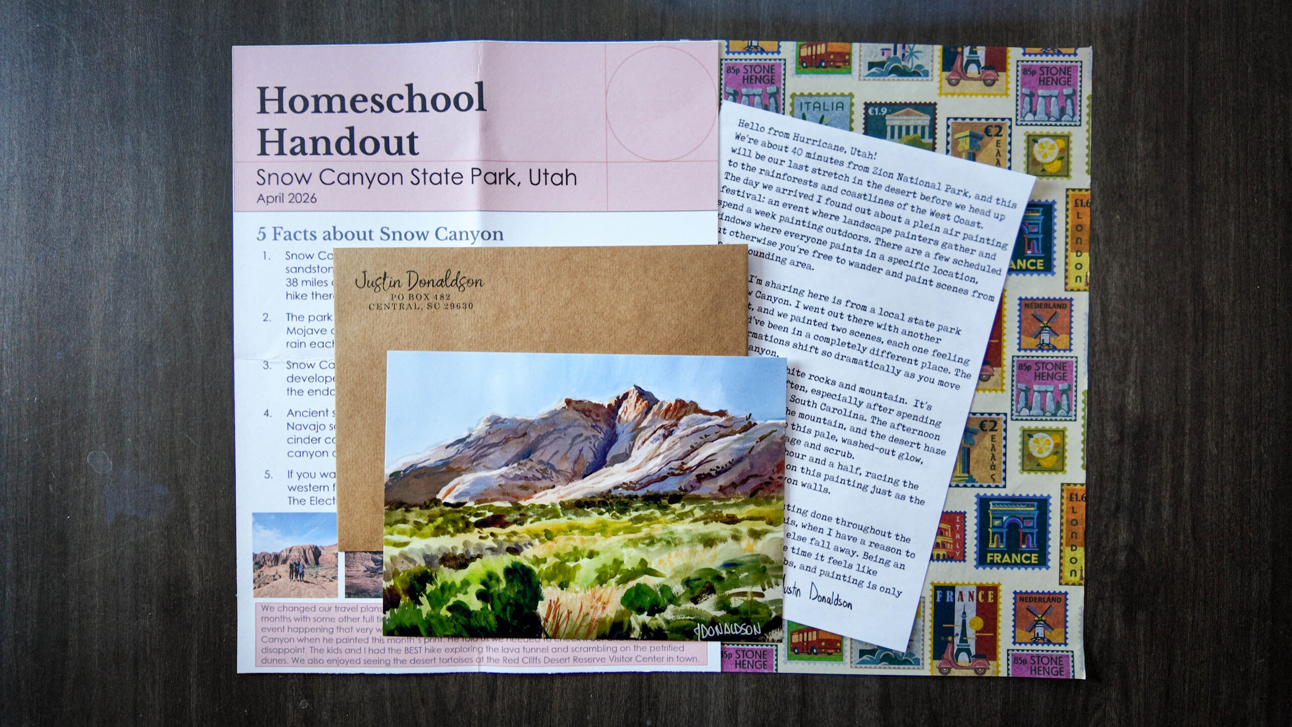 A flat lay with a landscape print of Snow Canyon Utah, envelope, letter, and homeschool handout